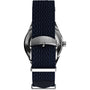 Close-up of the back of the Timex Marlin® Jet Automatic, featuring a navy blue woven strap and a silver TIMEX-engraved buckle. The metallic case reflects the retro-futuristic style iconic to this timepiece.