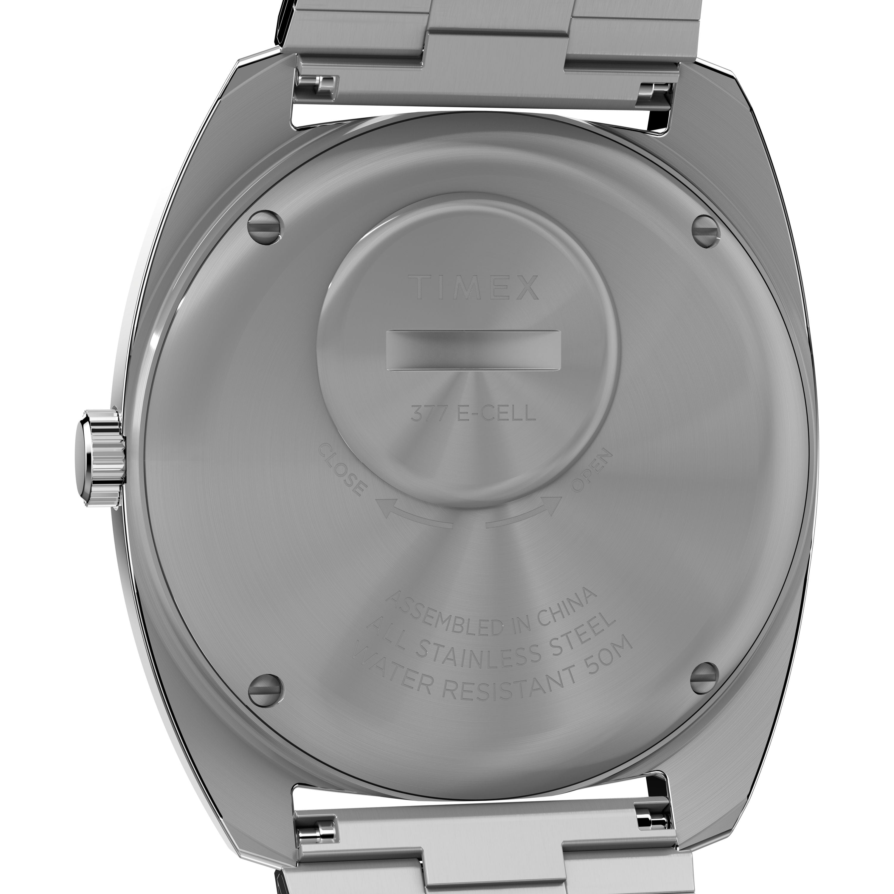 The stainless steel case back of the Timex Q Timex 1975 Enigma Reissue shows its battery compartment, engravings, and 50m water resistance. This watch features quartz movement and a classic metal band.