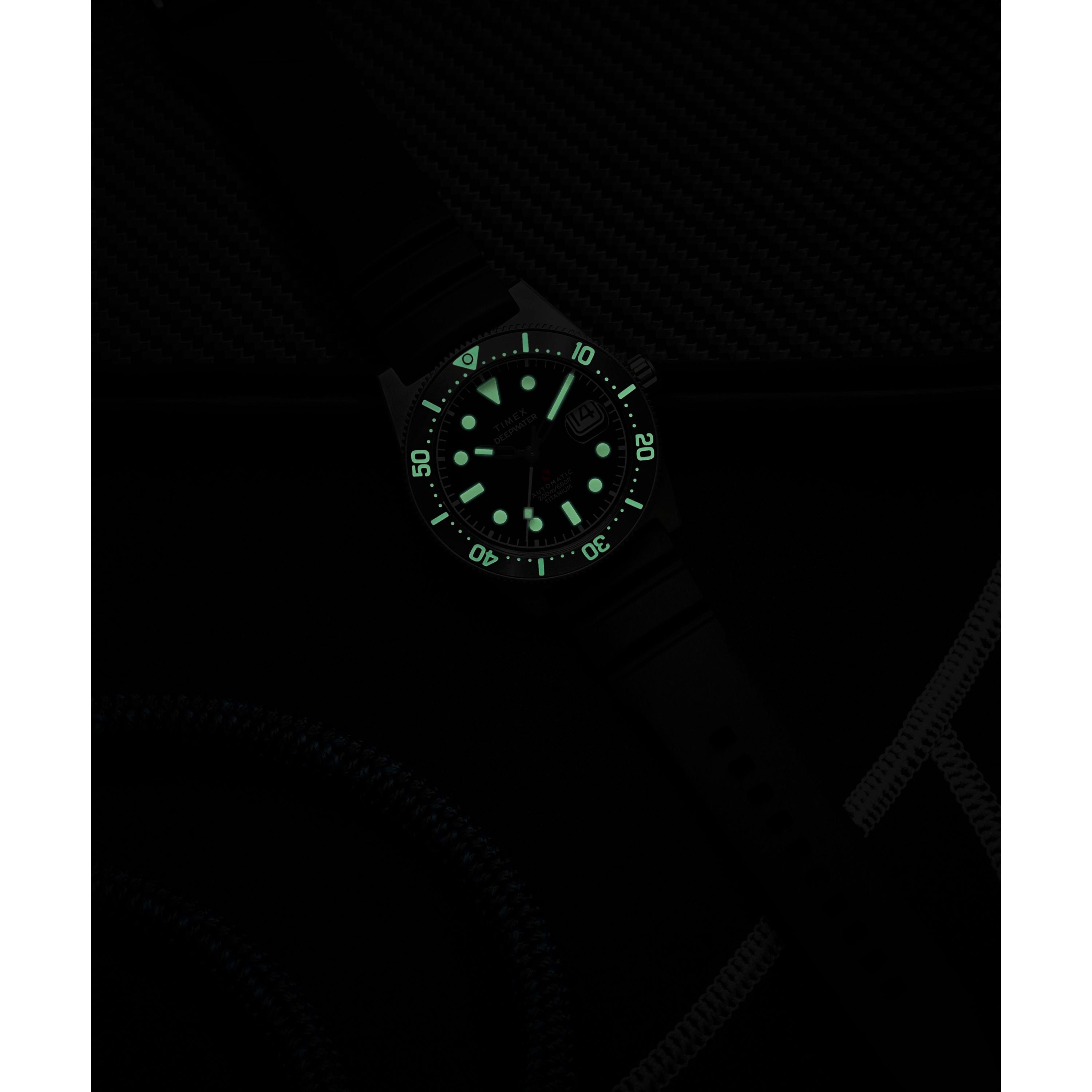The Timex G TI AU SW DEEP WTR REEF 41 BLAK DL 25 is a titanium automatic dive watch with glowing green markers and numbers for visibility in darkness, a black strap and dial, plus 200m water resistance.