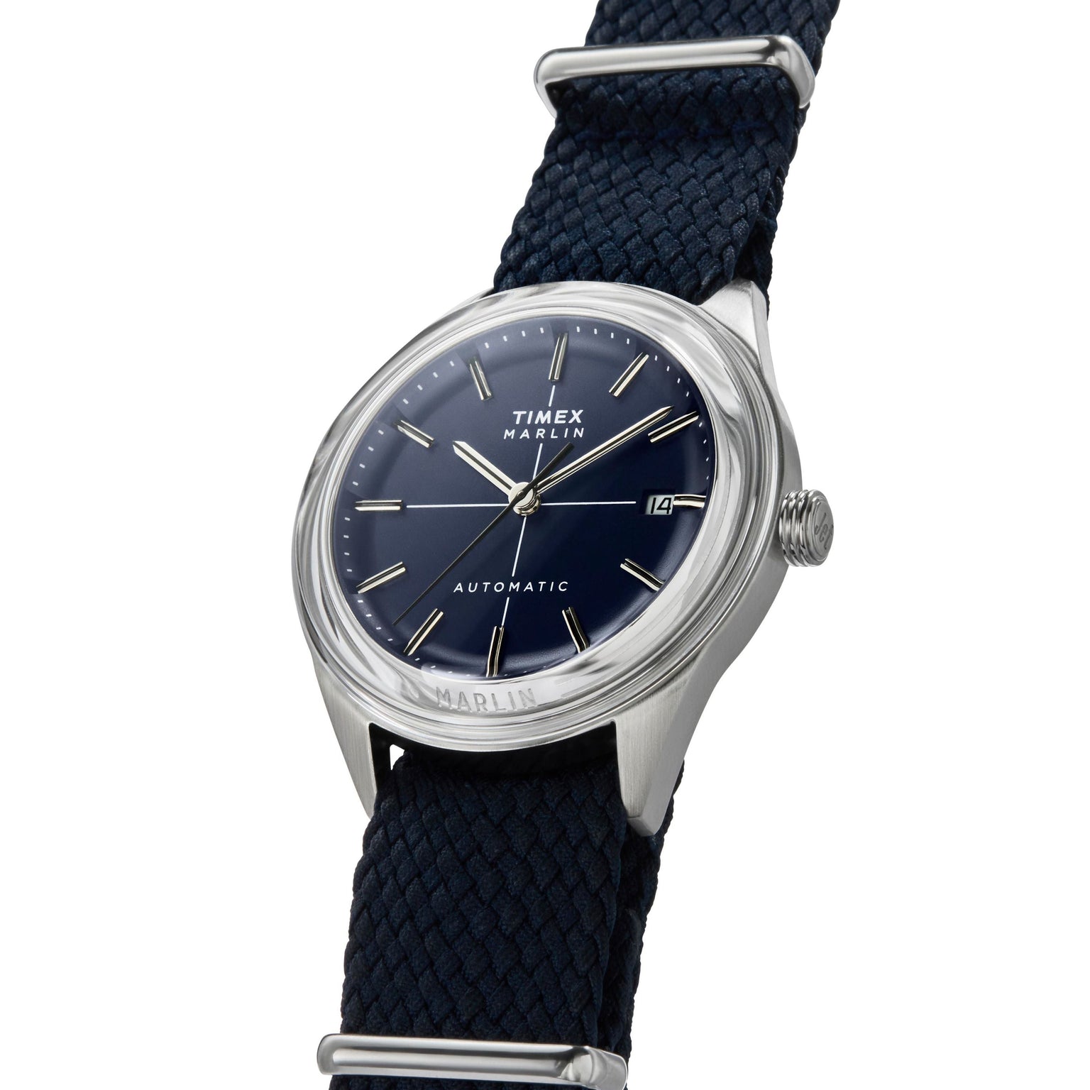 The Timex Marlin® Jet Automatic features a navy blue dial, silver hour markers, a braided navy strap, domed Hesalite crystal, polished silver case, and a date window at 3 o’clock for a refined retro-futuristic look.