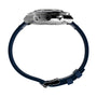 Side view of the Timex Q Chronograph racing watch, featuring a metallic case, two buttons, and a dark blue leather strap with buckle clasp. The watch's tachymeter bezel and face are not visible.