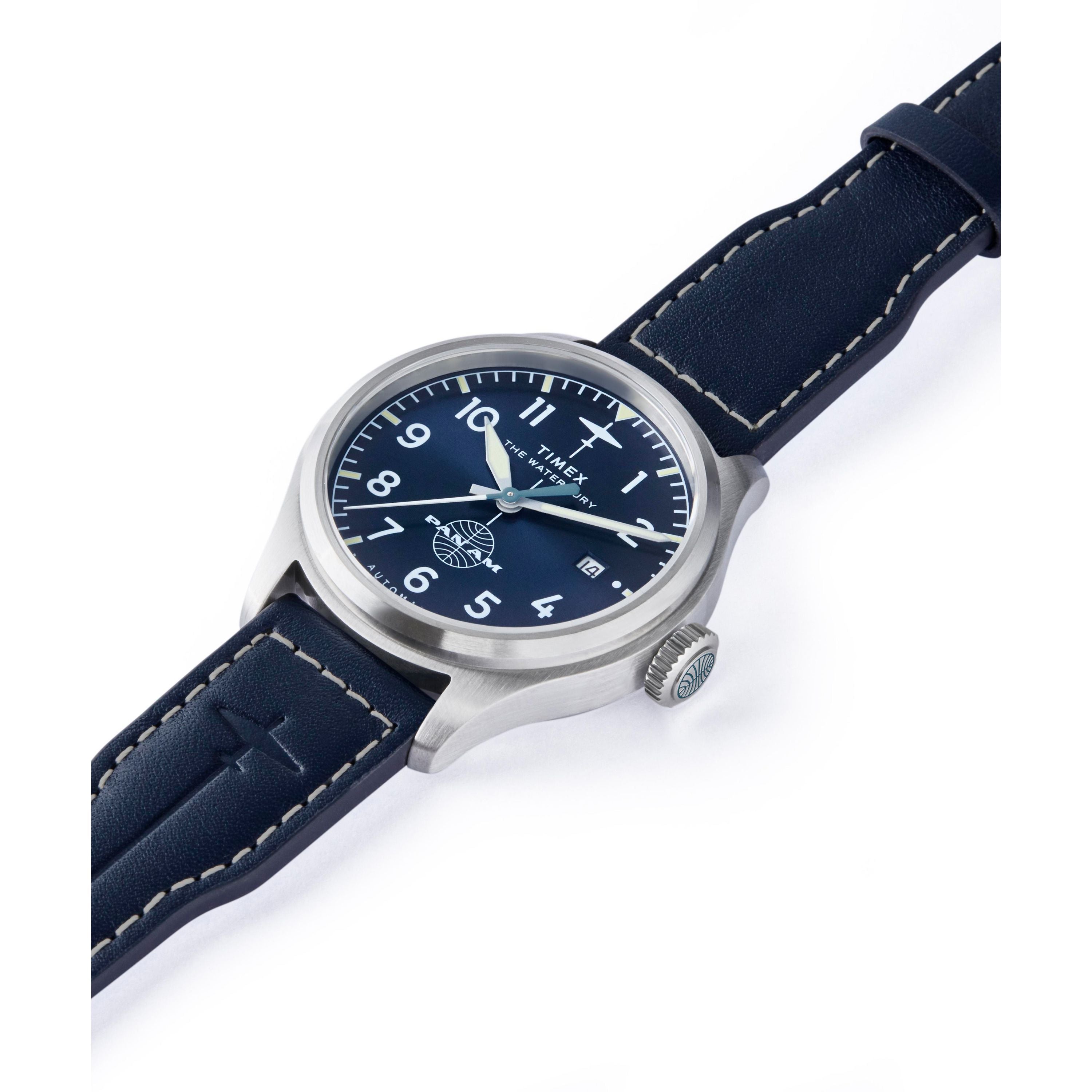 The Timex x Pan Am® Waterbury Automatic Ace features a silver case, blue face with white numerals, and a blue leather strap with white stitching, shown angled on a white background.
