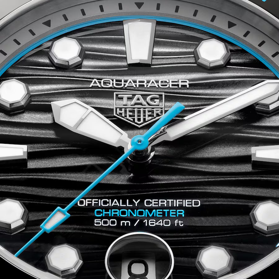 TAG Heuer Aquaracer Professional 500 watch face with blue hands, black dial, and white hour markers.