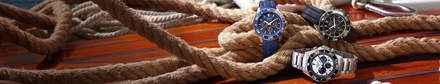Three watches on a wooden surface with ropes