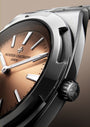 Silver watch with brown dial, white hour markers, and black leather strap displayed at an angle.