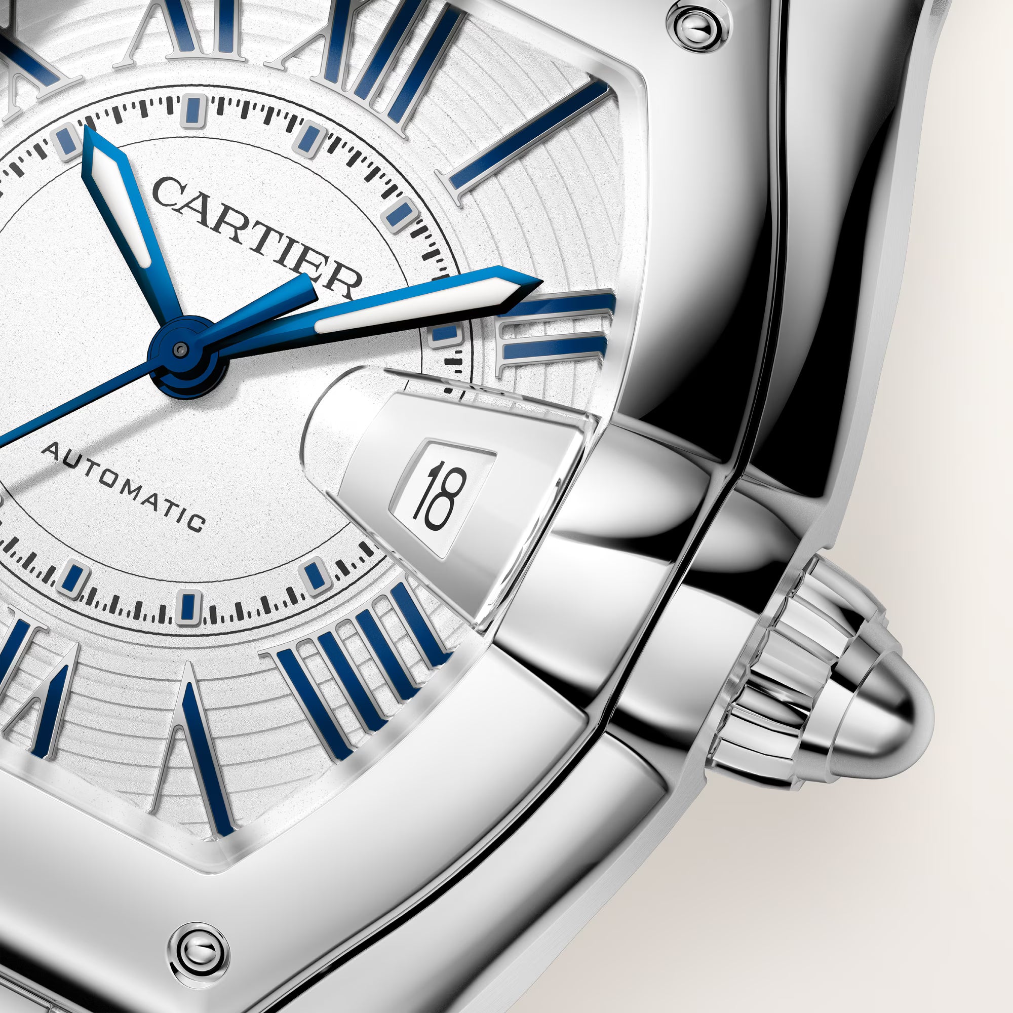 Cartier Roadster watch with white dial, blue hands and markers, date window showing 18, stainless steel case and bracelet.