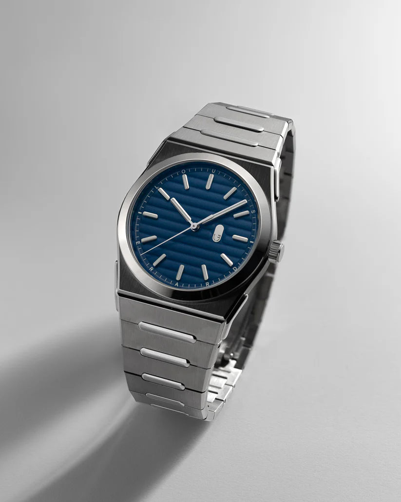 Silver watch with a blue face on a light gray background