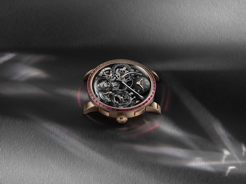Luxury watch with intricate design on a dark fabric background