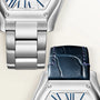 Two watches with silver tonneau cases and blue dial details, one with metal bracelet and one with dark blue leather strap.