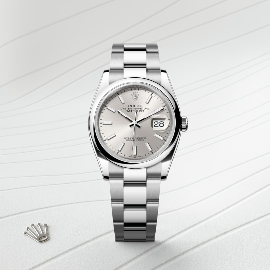 A silver Rolex Datejust watch with a metal strap and a date display on a textured white background.
