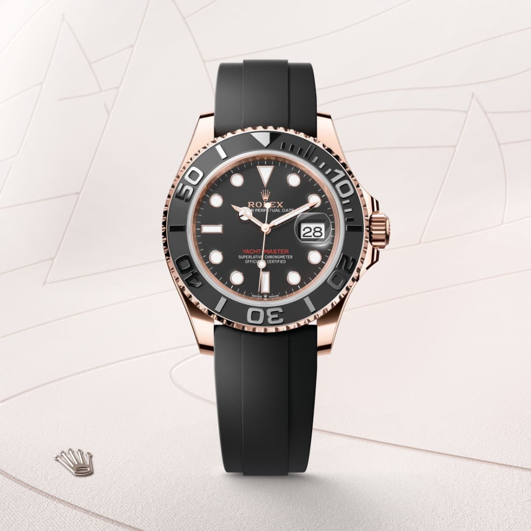 A black and rose gold Rolex Yacht-Master watch with a black rubber strap on a light background.