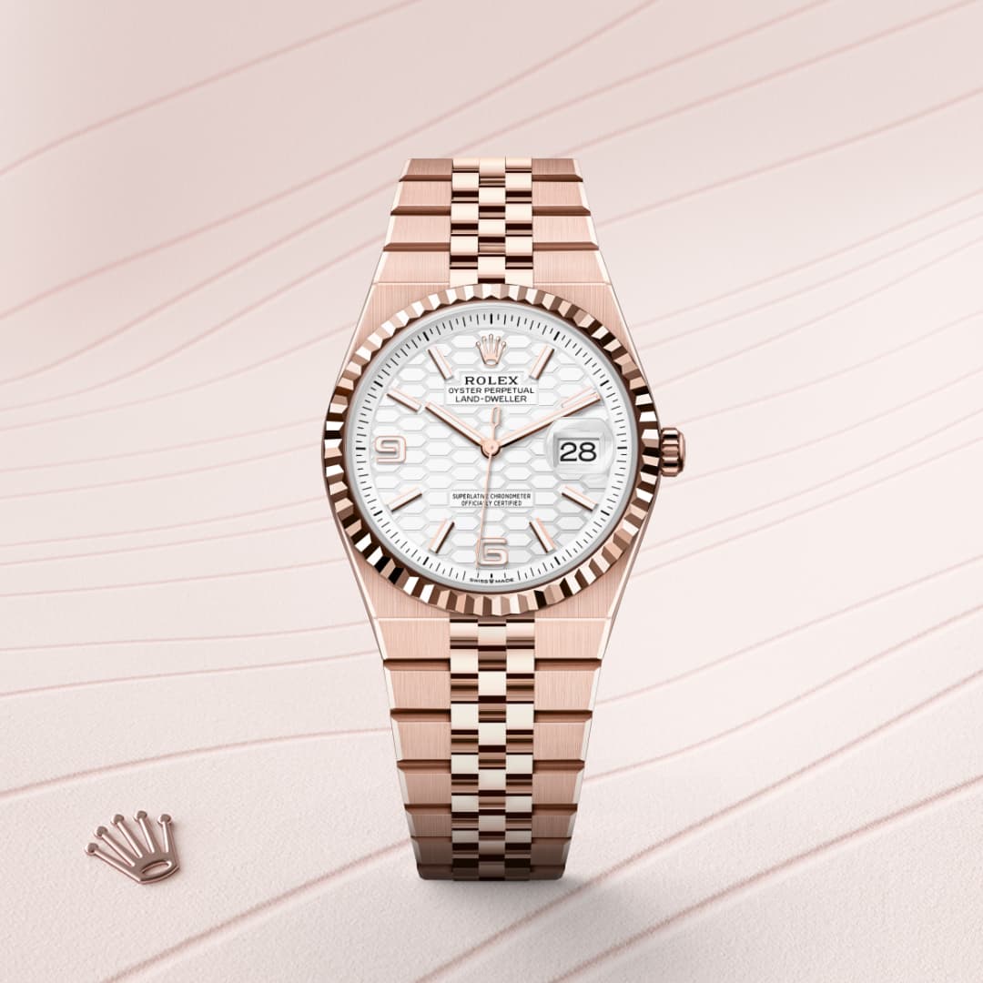 A rose gold Rolex wristwatch with a white dial and date display, on a patterned pale background.