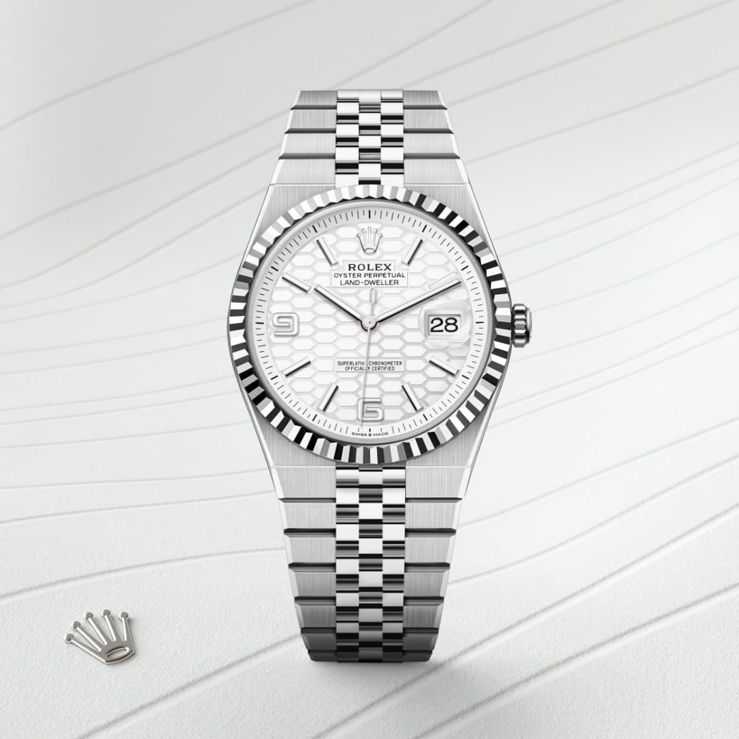 Silver Rolex watch with a white dial and metal bracelet, displayed on a light, textured background.