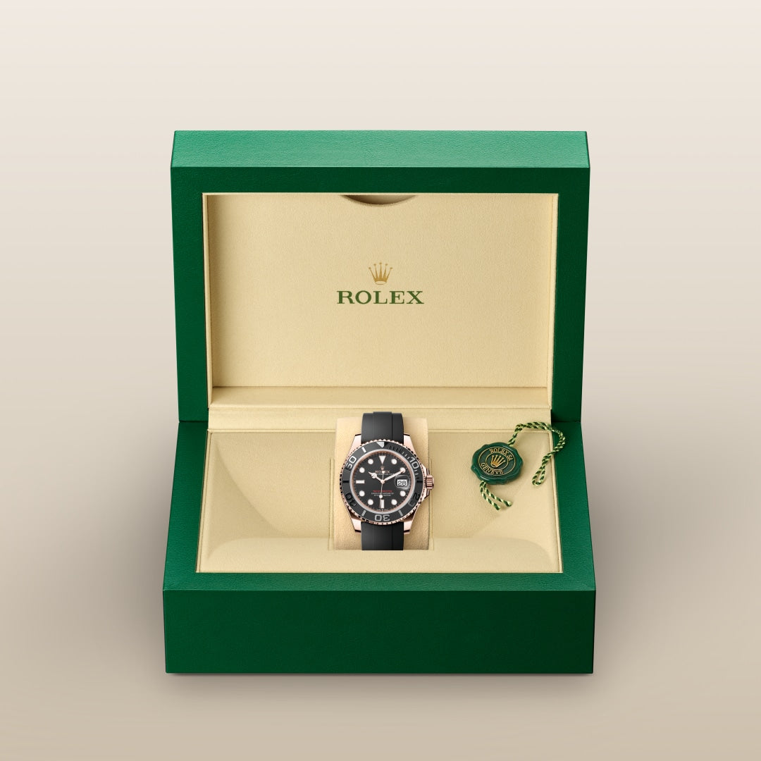 A Rolex watch with a black strap displayed in an open green and beige Rolex box.