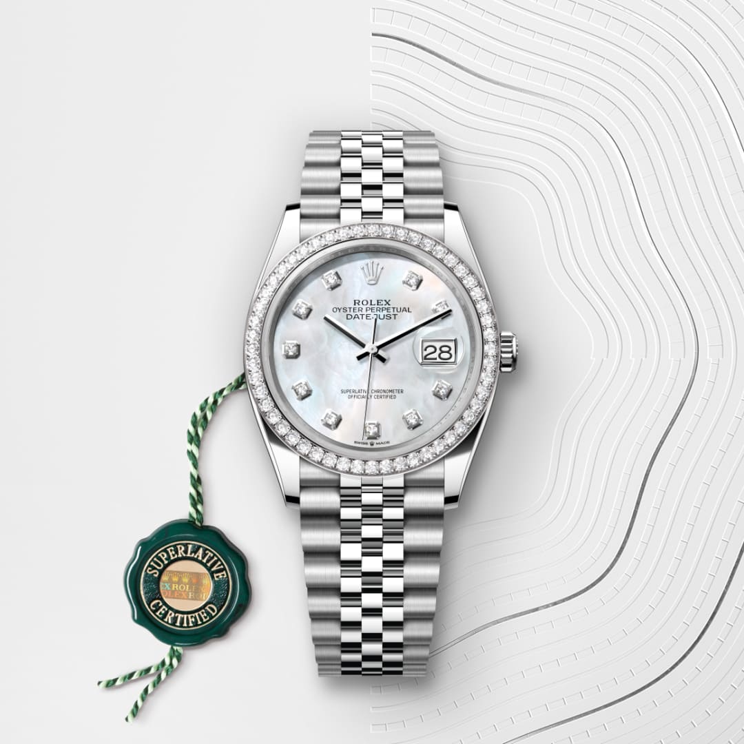 A silver Rolex watch with diamond markers and a jubilee bracelet, next to a green Superlative Certified tag.