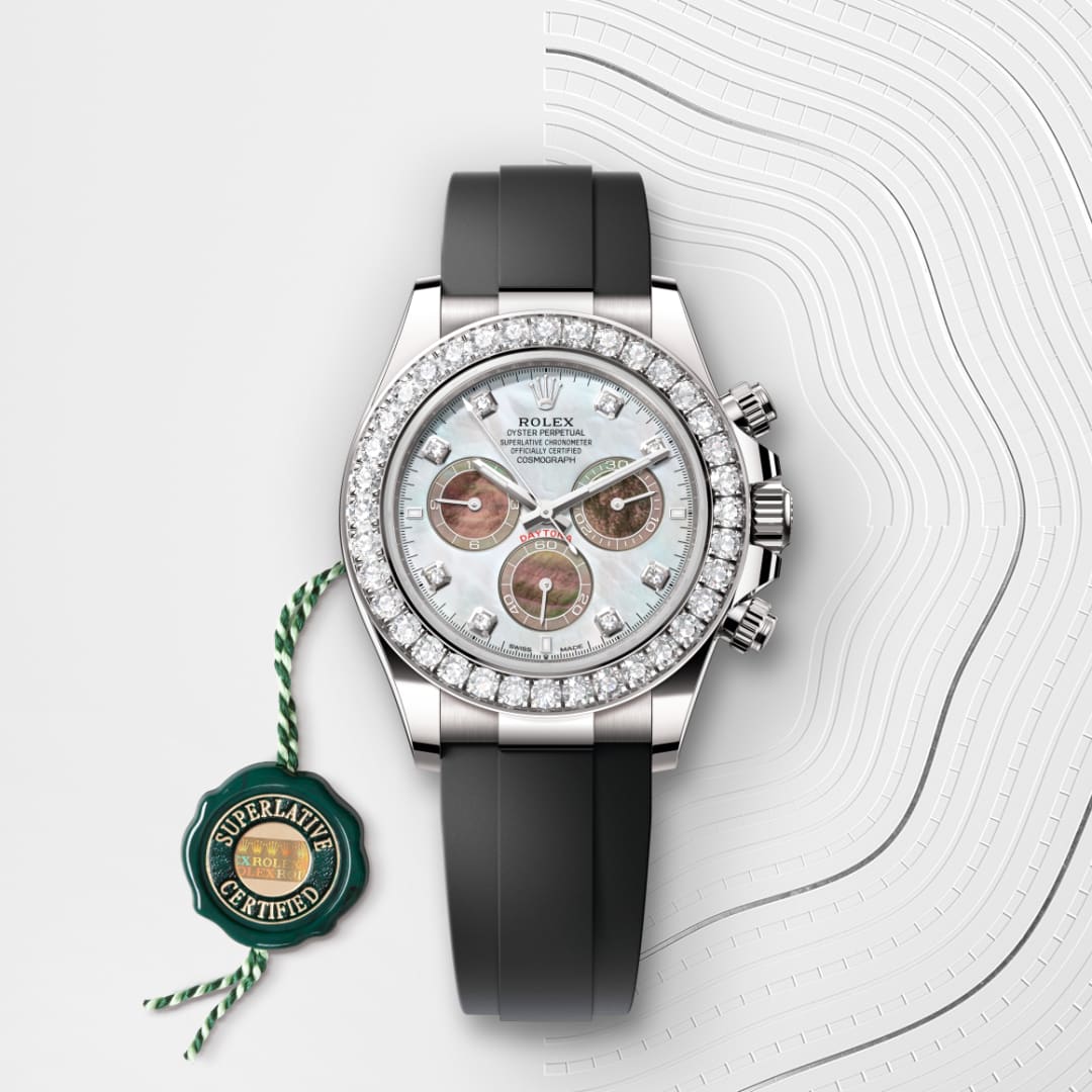 A luxury Rolex watch with a diamond bezel, black strap, and certification tag on a textured white background.