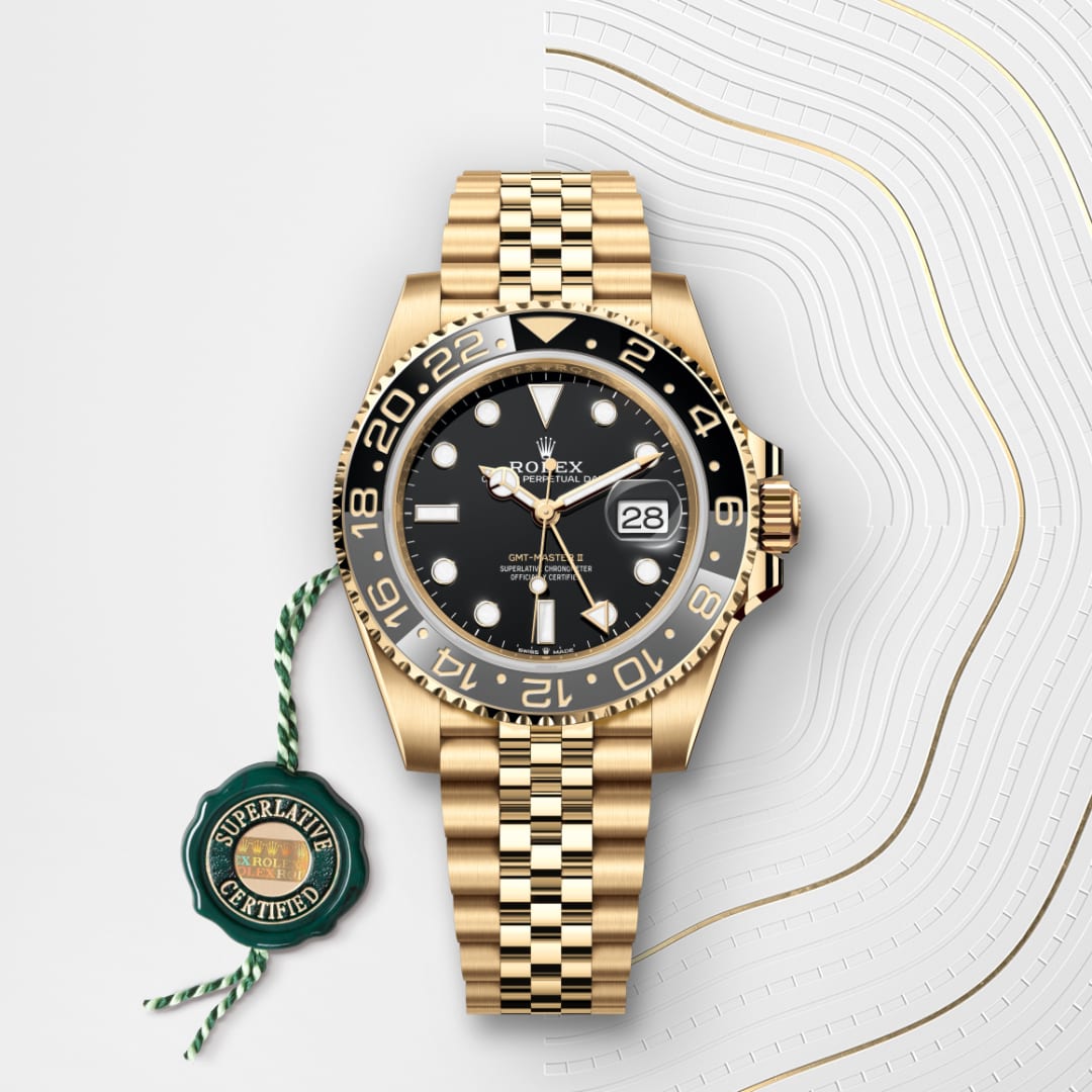 Gold Rolex watch with black face and date display, shown on a white patterned background with a green certification tag.