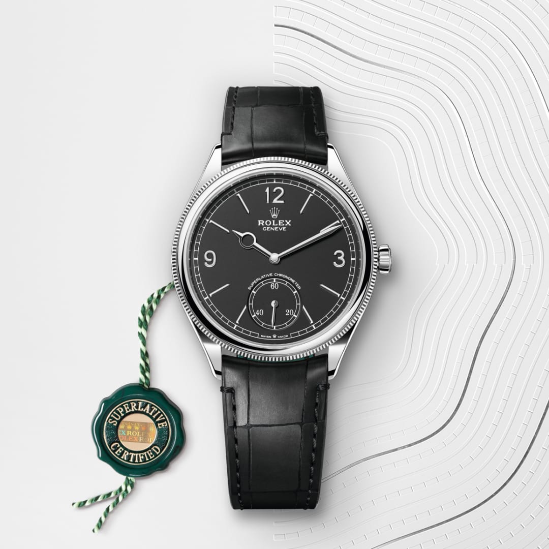 A Rolex wristwatch with a black leather strap beside a green Superlative Certified seal on a patterned surface.