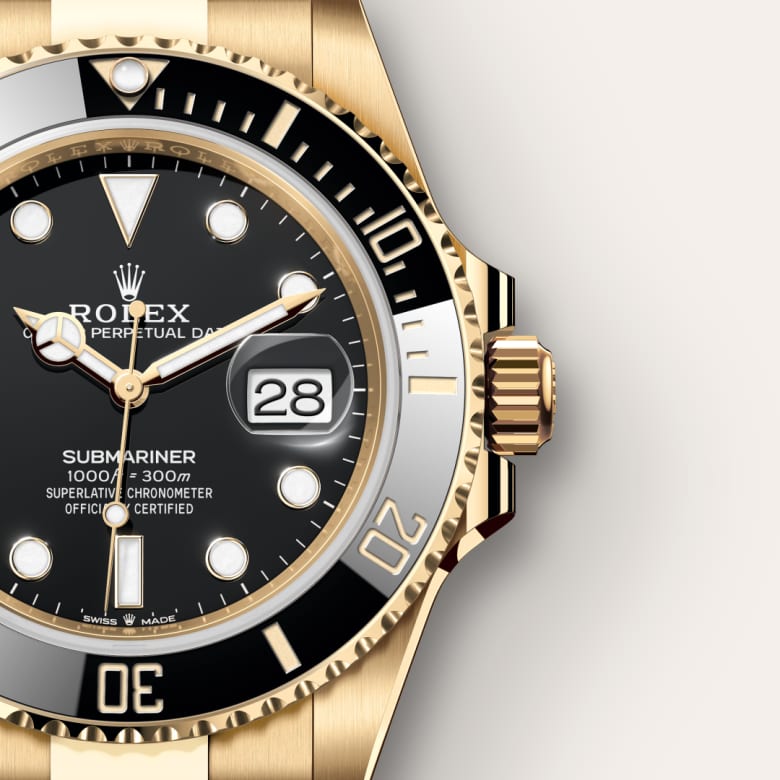 Close-up of a gold Rolex Submariner watch showing the date as 28 and water resistance marking.