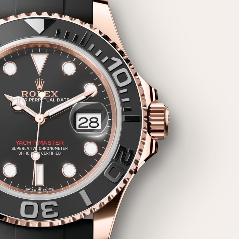 Close-up of a Rolex Yacht-Master watch with a black dial, gold bezel, and date shown as 28.