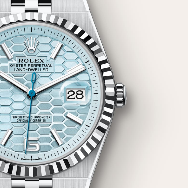 Close-up of a Rolex watch with a light blue honeycomb-pattern dial and silver hour markers, showing the date 28.