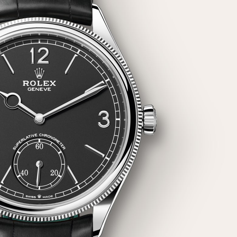 Close-up of a black Rolex wristwatch with silver trim, showing the time 10:10:33.
