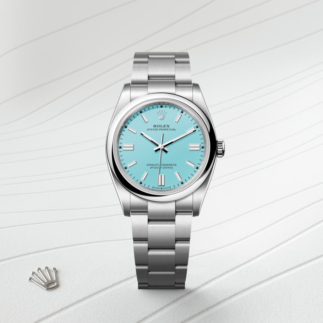 A silver Rolex wristwatch with a turquoise dial on a textured white background, next to a small crown logo.