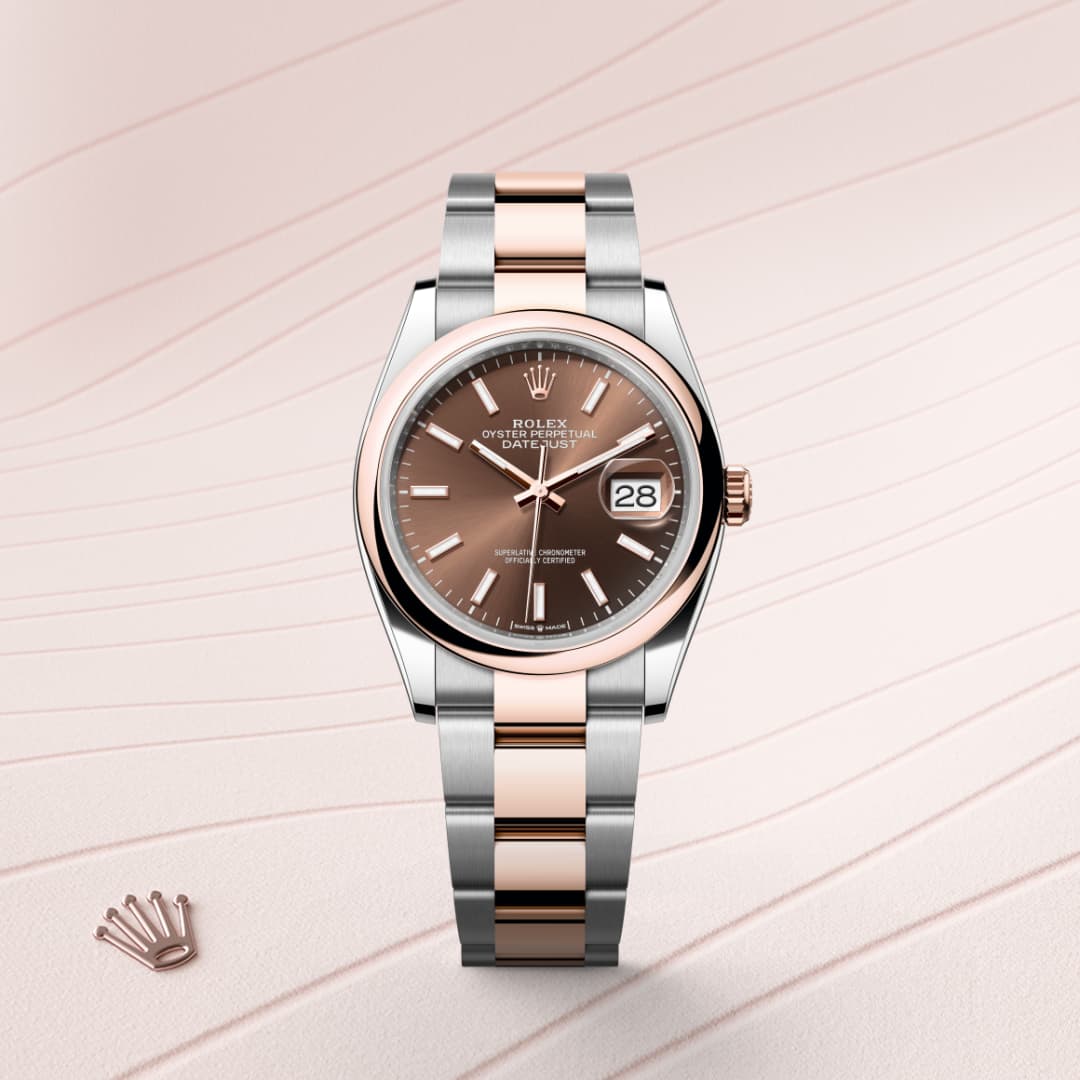 A Rolex watch with a brown dial, silver and rose gold bracelet, and a visible date display on a pale background.