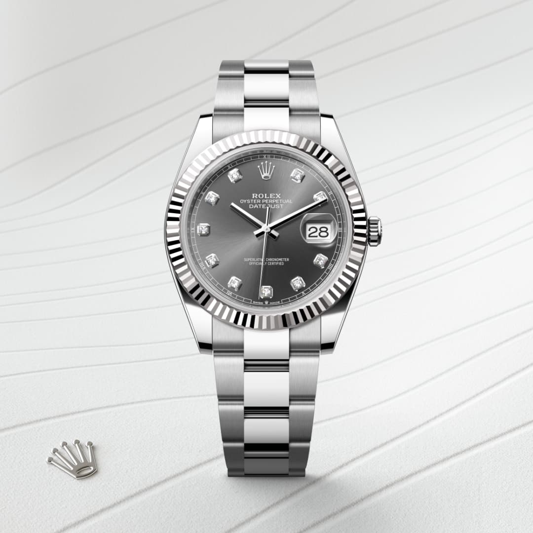 Silver Rolex watch with diamond hour markers and date display on a textured white background.