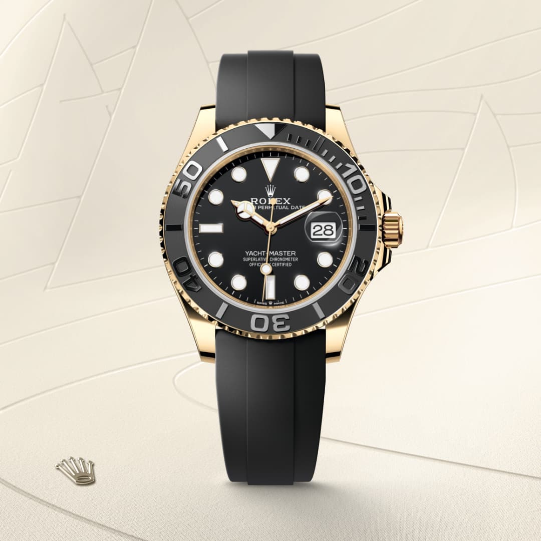 Rolex Yacht-Master watch with a black strap, black bezel, and gold accents on a light textured background.