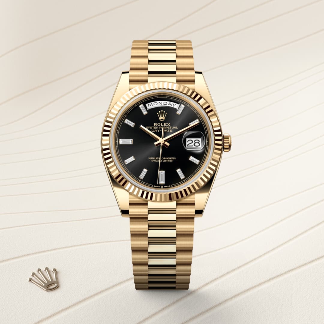A gold Rolex watch with a black dial displaying the day and date, placed on a textured beige surface.