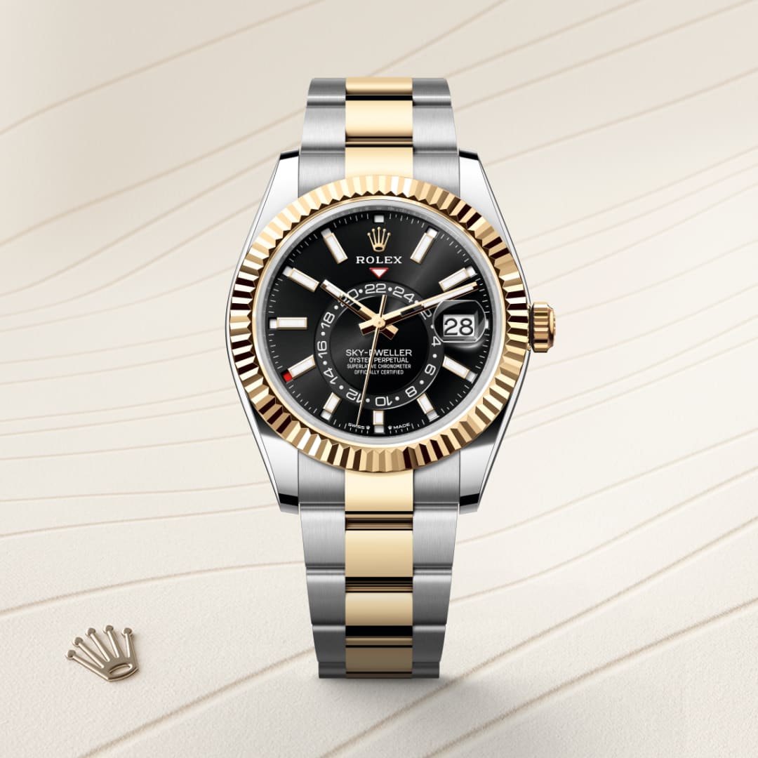 A two-tone Rolex Sky-Dweller watch with a black dial and gold bezel on a light textured background.