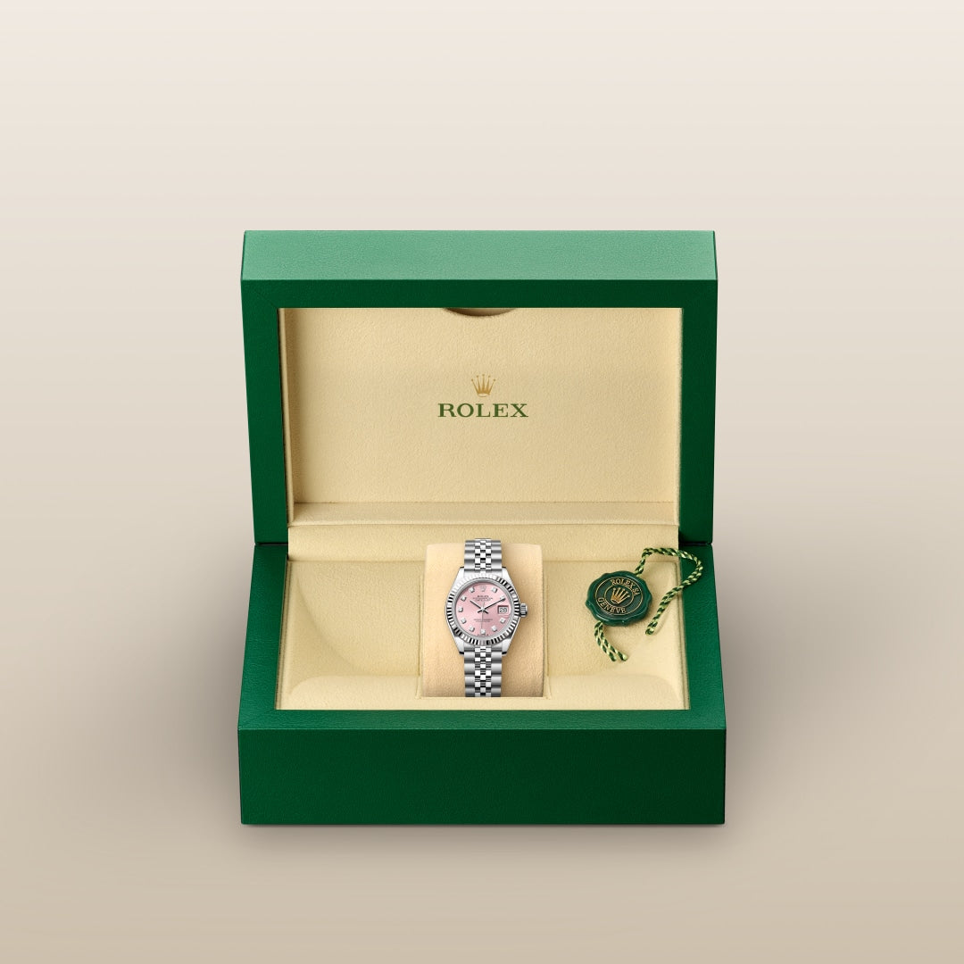 A Rolex watch with a pink dial in a green and beige box, accompanied by a green tag.