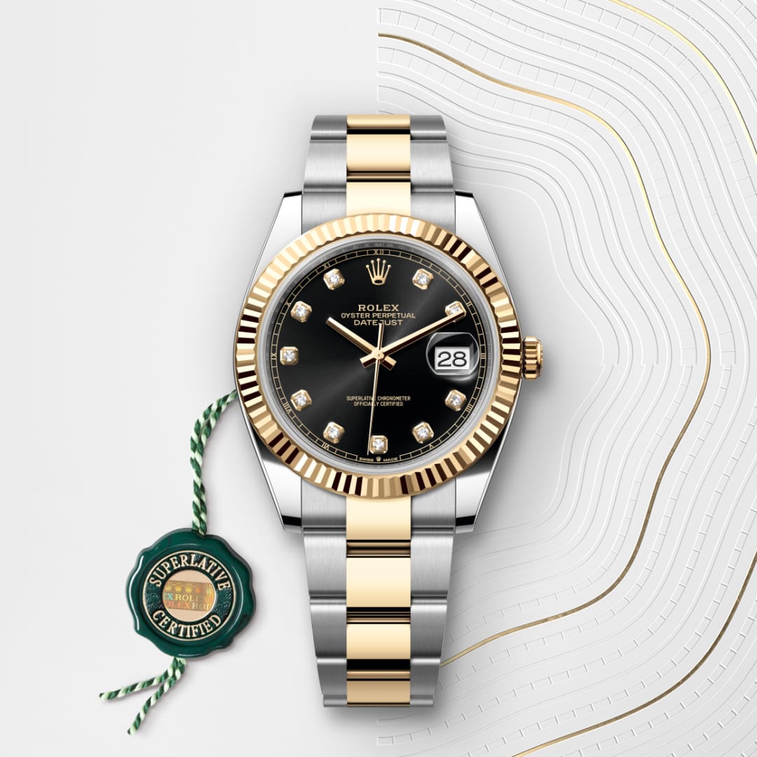 A Rolex Datejust watch with a black dial, gold accents, and a Superlative Certified tag on a white patterned background.