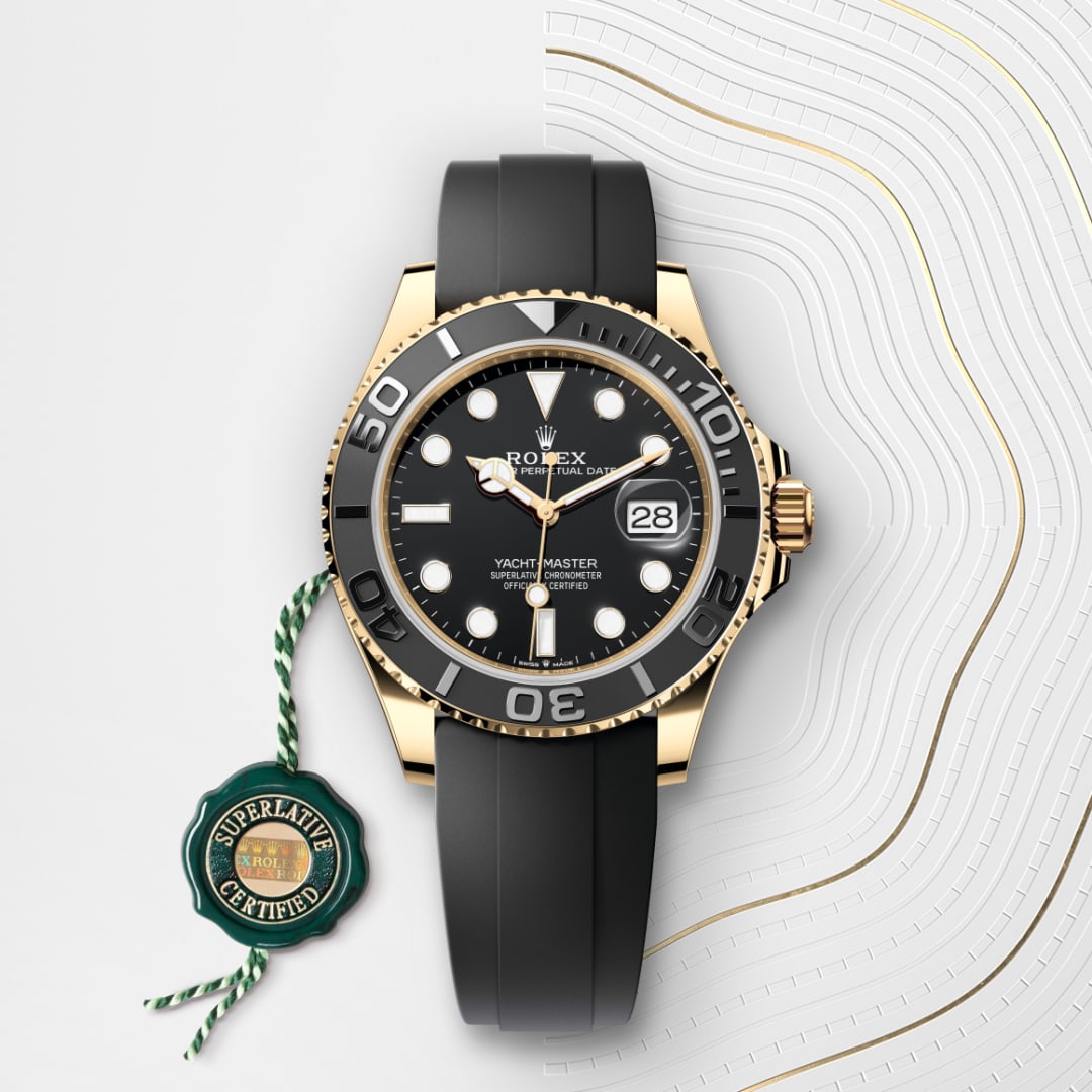 A Rolex Yacht-Master watch with a black strap and gold accents, displayed next to a Superlative Certified tag.