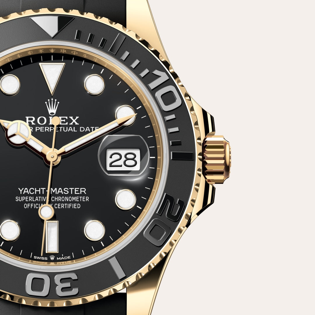 Close-up of a Rolex Yacht-Master watch with a black dial, gold accents, and the date showing 28.