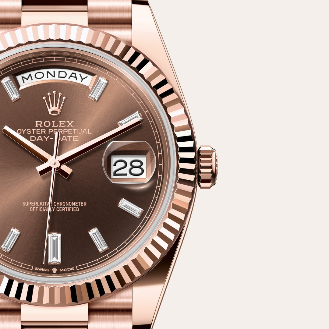 Close-up of a rose gold Rolex Day-Date watch with a brown dial, diamond hour markers, and date window.