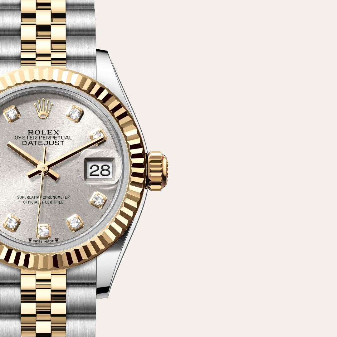 Close-up of a Rolex Datejust watch with a silver face, gold bezel, and diamond hour markers.