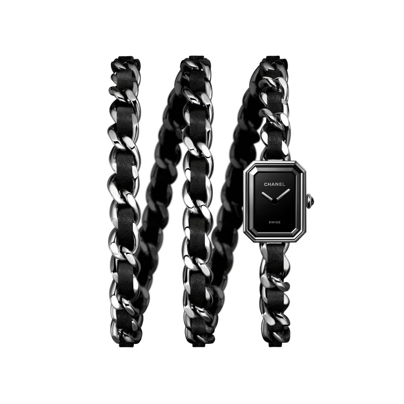 The Chanel Première Iconic Chain watch features black leather, a black-lacquered dial, and a long silver chain-link strap coiled in three loops against a white background.