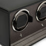 Black watch winder with two circular chrome-rimmed compartments and control buttons on textured front panel.