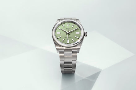 Rolex Oyster Perpetual with green dial on light grey background