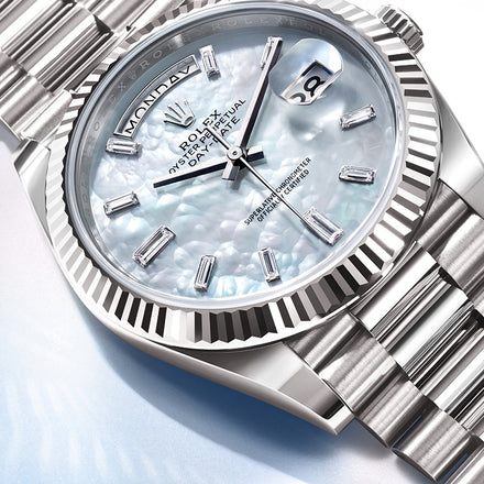 Close-up of a silver Rolex watch with a mother-of-pearl dial and diamond hour markers, showing the date and day.