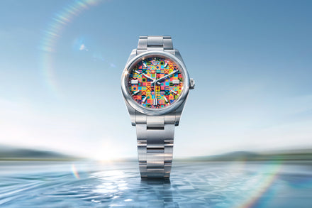 Silver watch with a colorful face on a blue water background