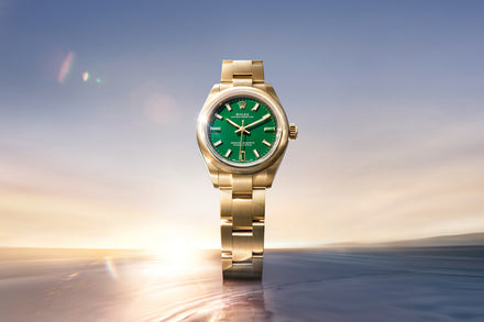 Gold watch with a green face on a blurred background