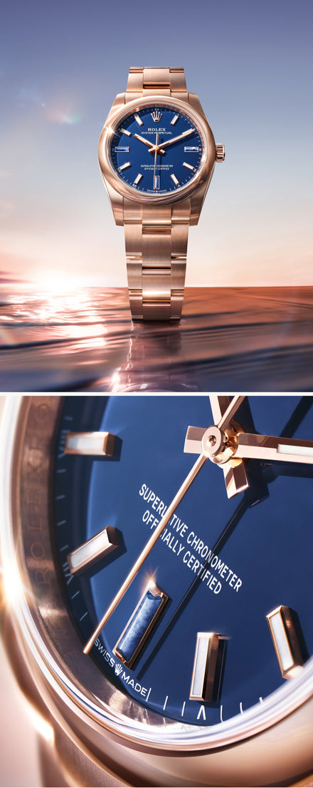 Rose gold watch with blue dial on a reflective surface