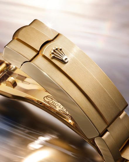 Close-up of a gold Rolex watch with a blurred background