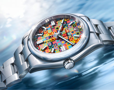 Silver watch with a colorful face on a blue water background
