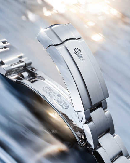 Close-up of a silver watch clasp with a blurred background