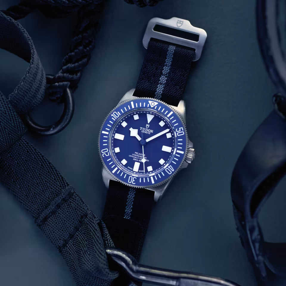 Watch with blue dial and black strap on a dark background