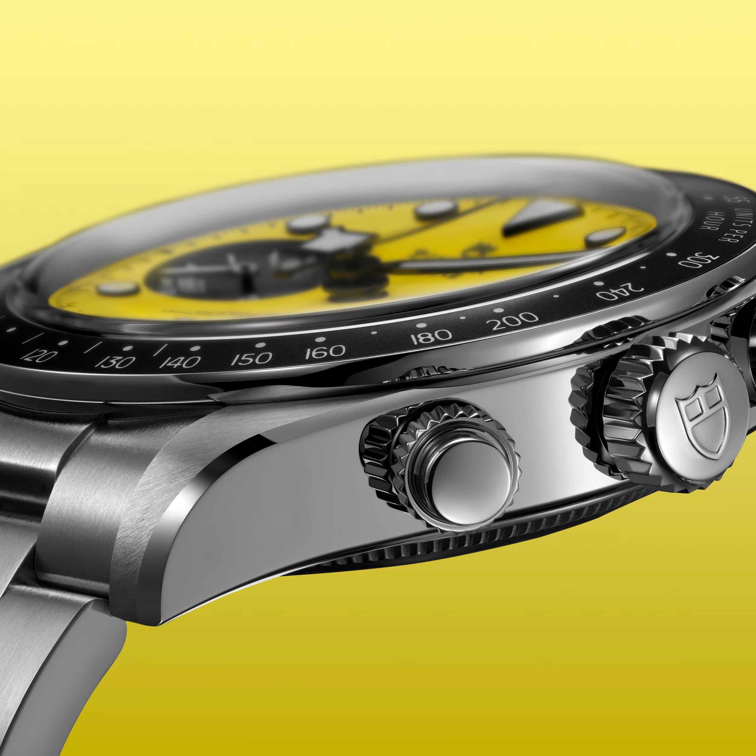 Black and yellow chronograph watch with black bezel, stainless steel case, and metal bracelet against yellow background.